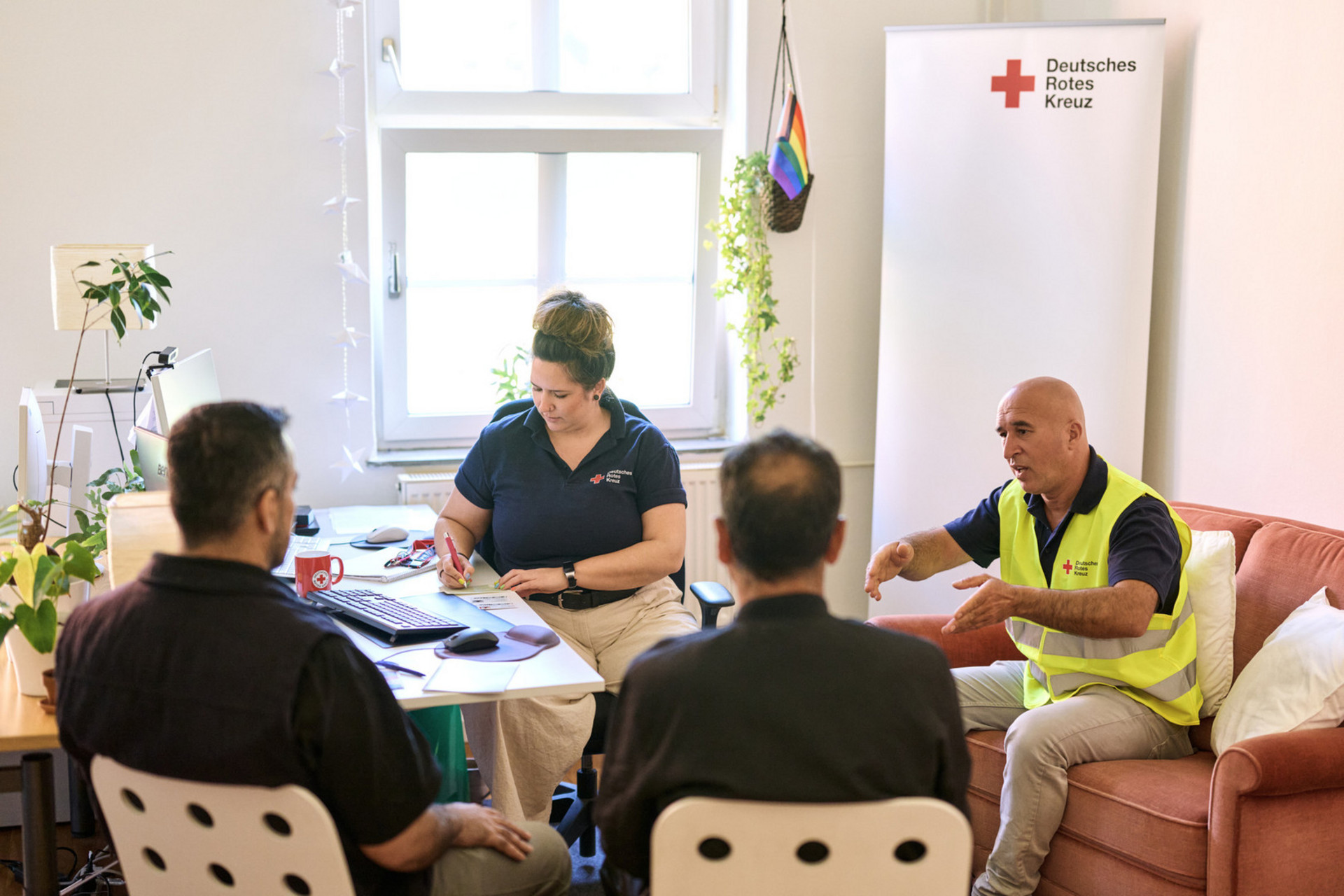 DRK-Mitarbeitende beraten zwei Menschen