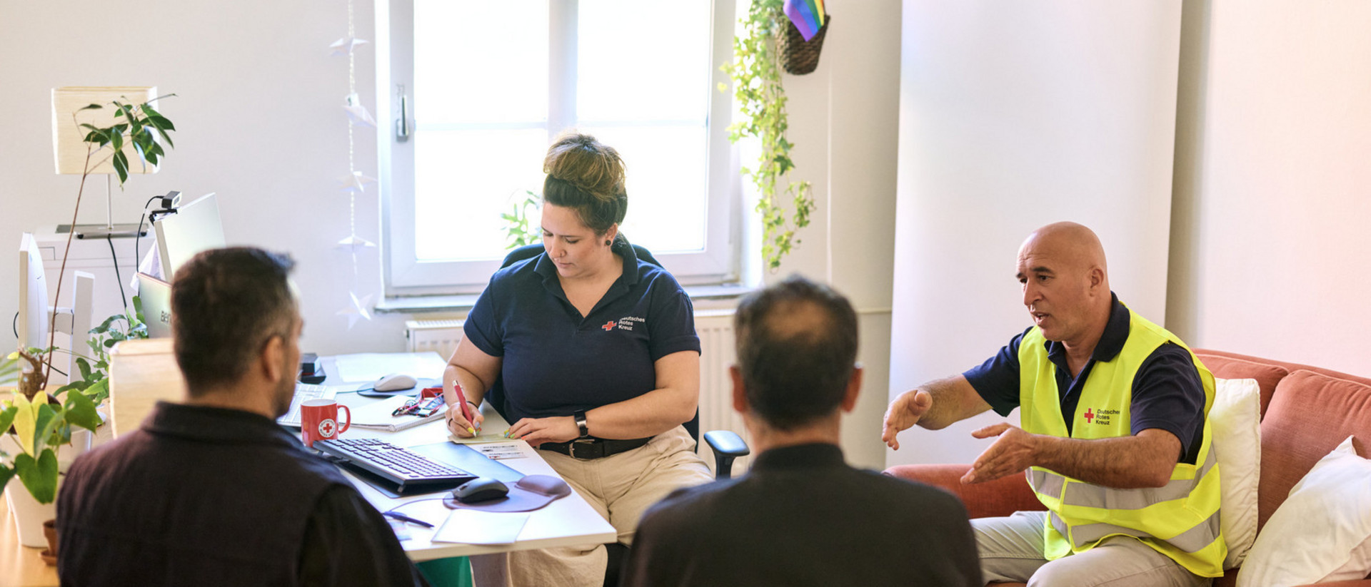 DRK-Mitarbeitende beraten zwei Menschen